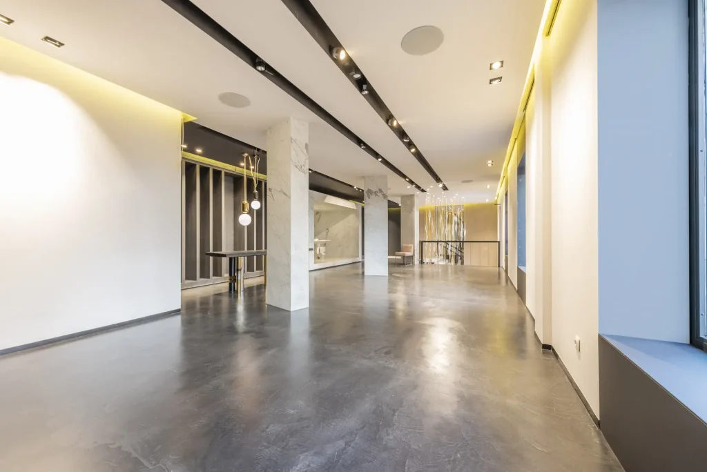 An empty commercial premises with polished concrete floors and installation of lights in the ceilings